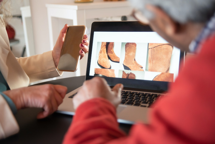 Laptop, der einen Onlineshop mit 6 Produktbildern von einem braunen Lederstiefel zeigt